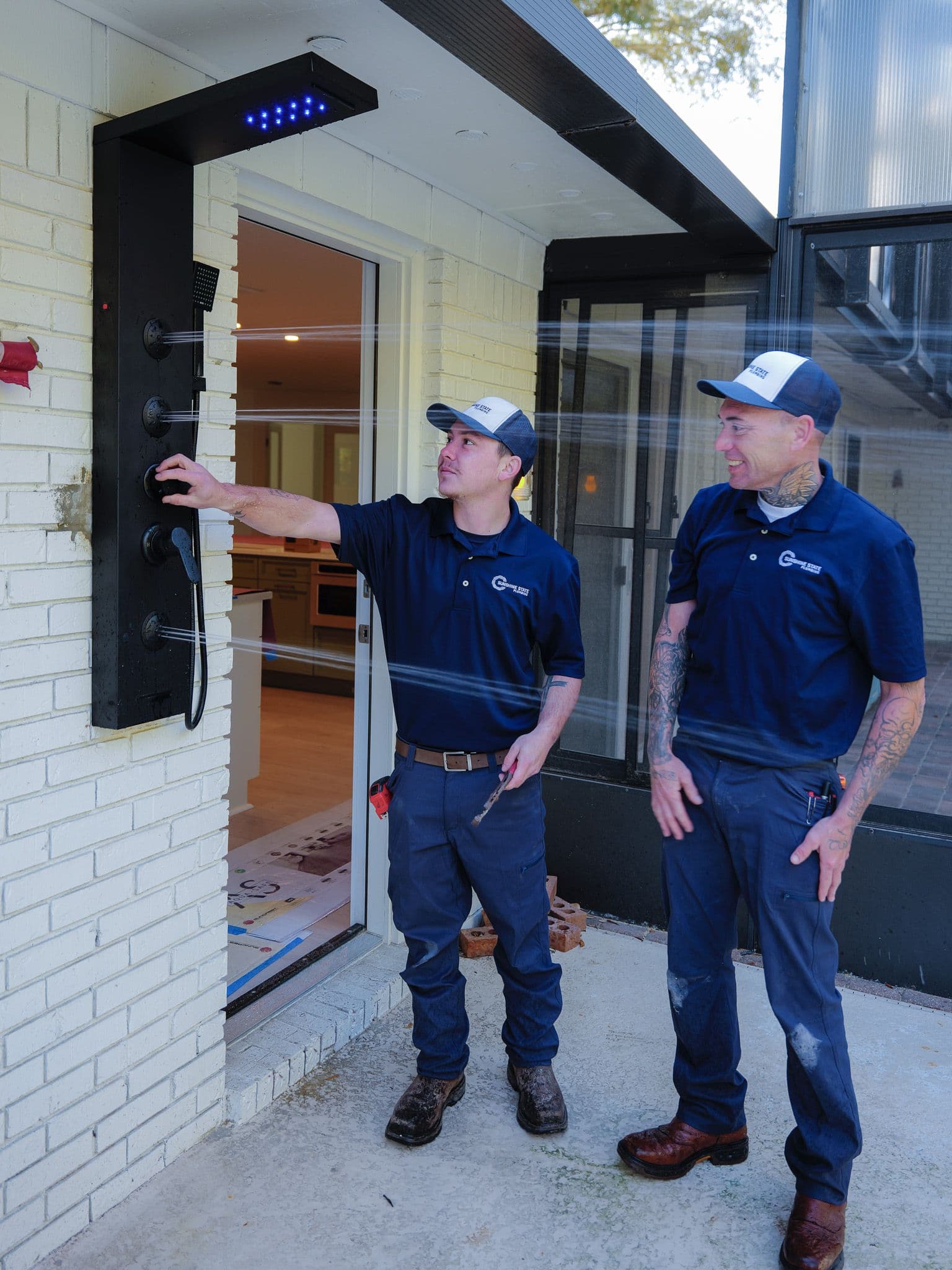 Sunshine State Plumbing technicians testing a newly installed poolside outdoor shower