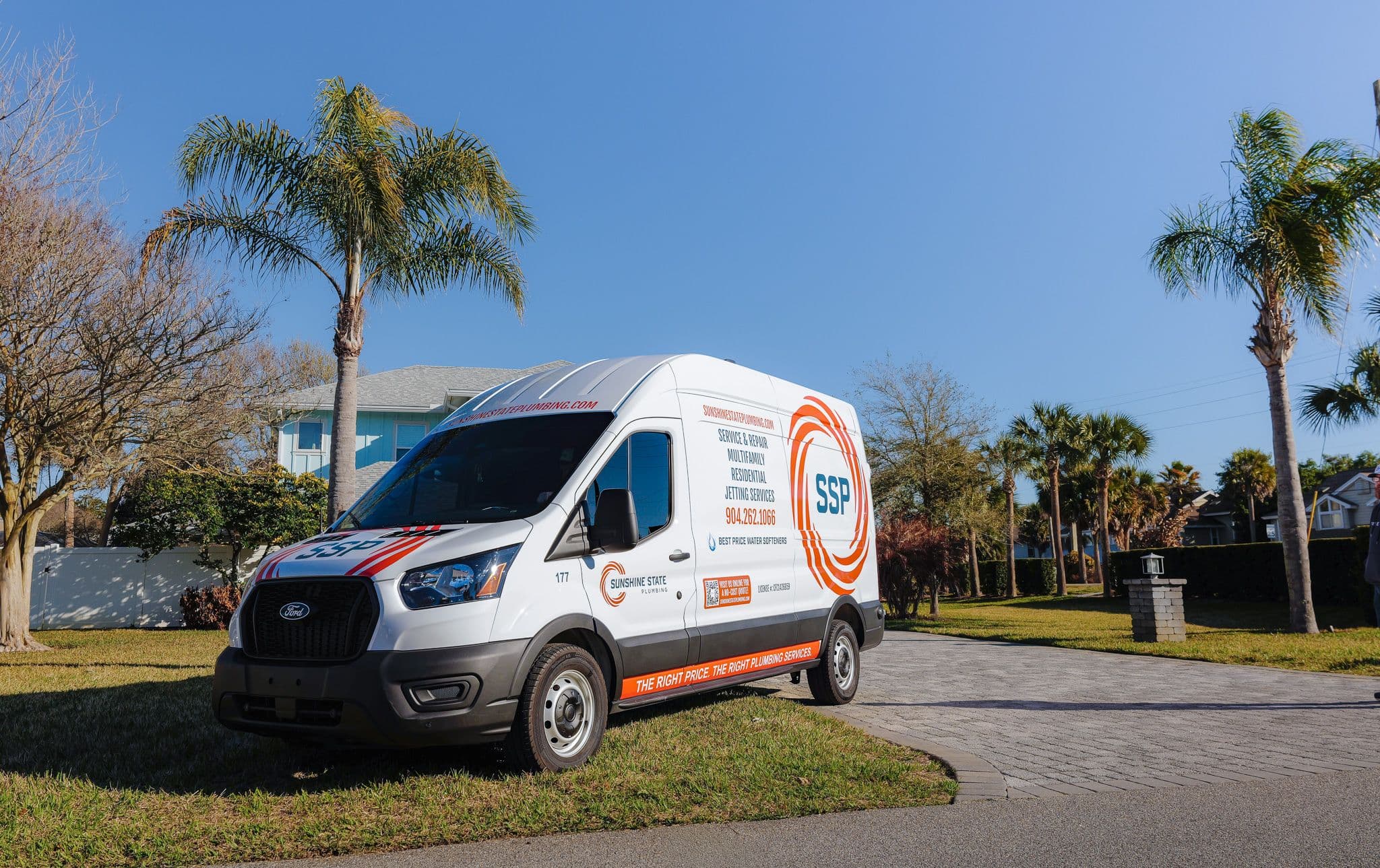 A wrapped Sunshine State Plumbing service van parked among palm trees