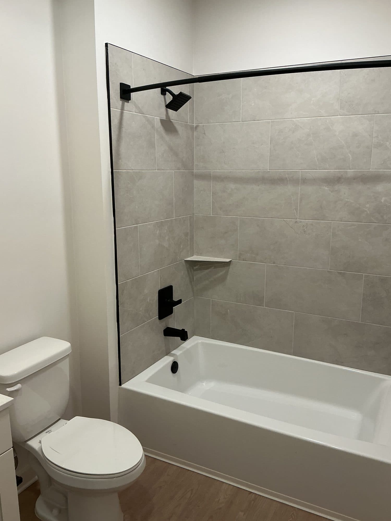 Finished apartment bathroom with tub and shower fixtures trimmed out