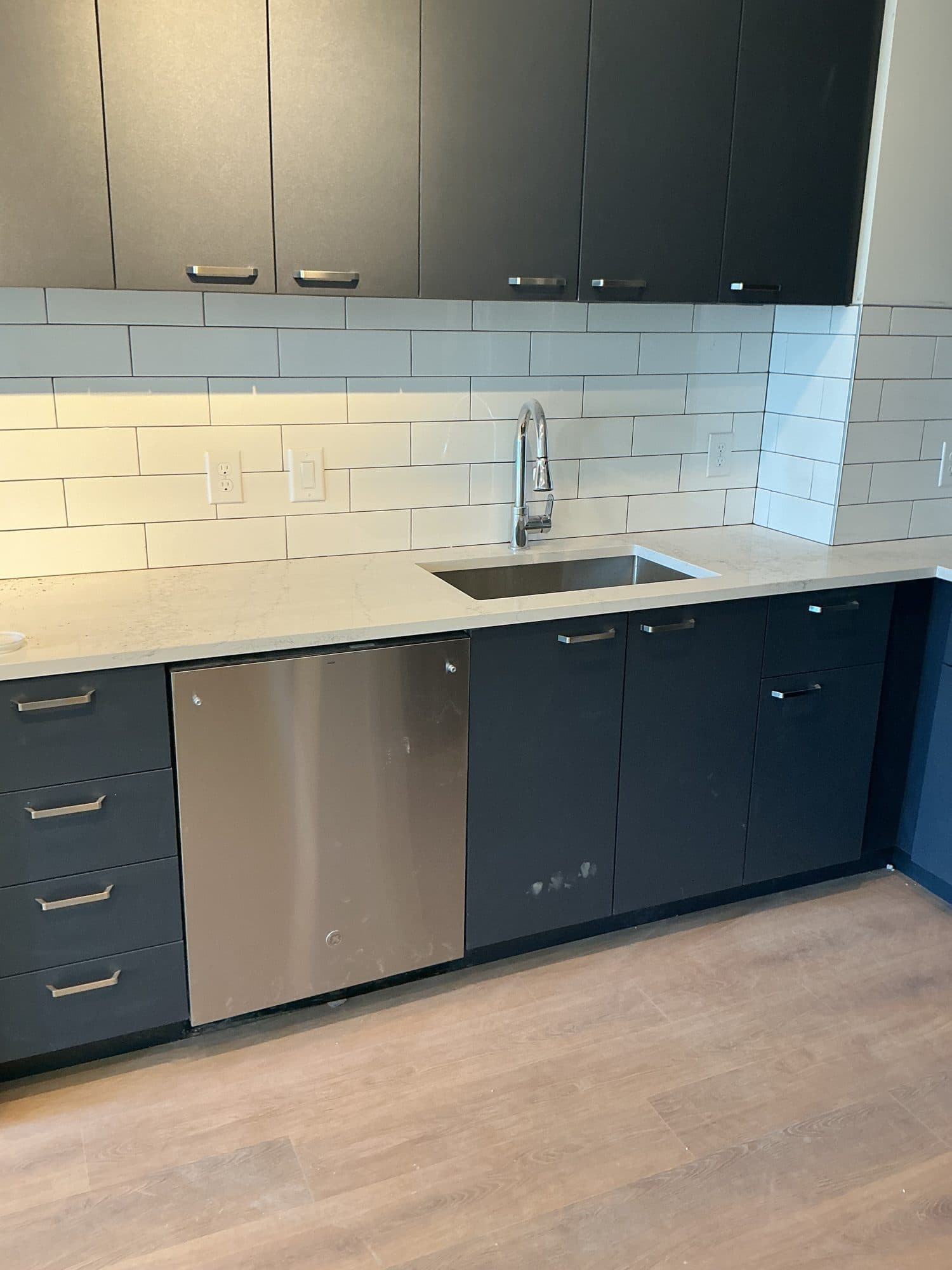 Finished apartment kitchen with sink and dishwasher plumbing trimmed out